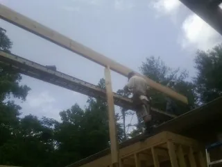 Carpenter setting a ridge beam over a new addition frame — Ice Dam Removal by Roofing Brothers in Chadds Ford