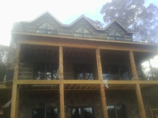 Dormers and porch framing on a large log home under construction — Roof Coating work by our crew in Chadds Ford